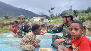 Buaya Putih Berbagi di Minggu Kasih, Pos Gome Satgas Yonif 323 Bagikan Makanan untuk Masyarakat