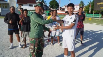 Personel Satgas TMMD Ke-129,Serahkan Bantuan Bola Kaki kepada Karang Taruna Desa Umbele